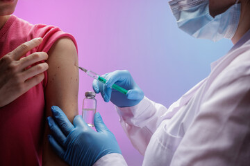 Vaccination process: woman receiving vaccine in modern clinic, close-up