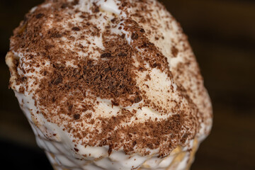 sweet melting white ice cream with chocolate chips in a waffle cone