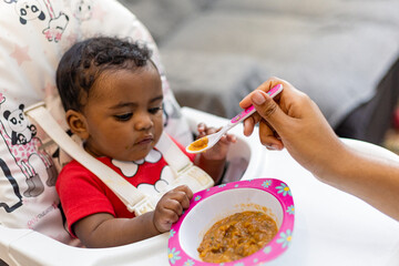 Spontaneous reaction of a child when introduced to food, eating for the first time. Rio de Janeiro,...