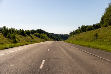 Fototapeta premium an empty straight paved road against a blue sky background