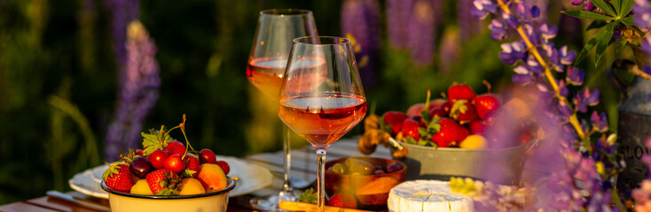 Banner. Perfect surprise date for loving couple, private wedding, romantic marriage proposal. Summer, sunset, golden hour. Beautiful elegant outdoor arrangement in meadow with purple blue lupins