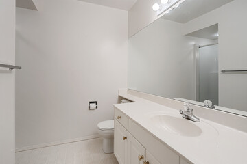 A bathroom with a white toilet, sink, and mirror