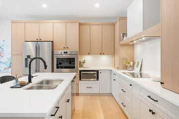 The kitchen is very clean and well-organized, with a lot of white cabinets