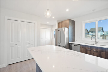 A kitchen with a white countertop and stainless steel appliances