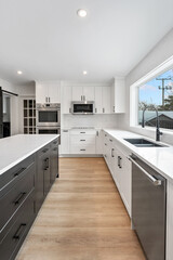 A kitchen with white cabinets and a black island