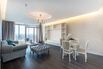 Elegant Modern Home Living Room with Open Kitchen and Stylish Interior Design. Bright and spacious modern living room with dining area and open kitchen, featuring elegant furniture and tasteful decor.