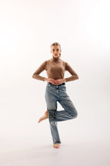 Dancer performing a graceful pose in a minimalist studio setting during a creative ballet rehearsal