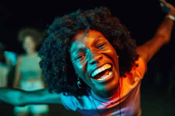 Young woman dancing with open arms and laughing at night