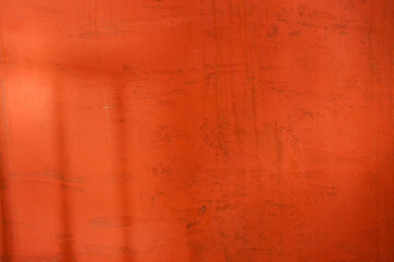 Empty red textured wall close up with shadows. Sparse texture and background