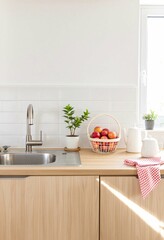 Modern minimalist kitchen interior with wooden cabinets, stainless steel sink, fresh apples and small plants. Bright scandinavian home design with natural light and white walls