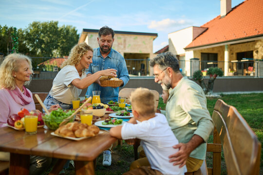Happy family enjoying weekend brunch together in backyard