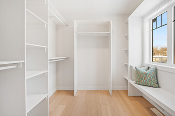 A white room with a bench and a window