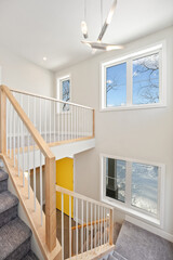 A staircase with a yellow door leading to a second floor