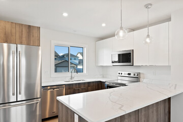 A kitchen with a stainless steel refrigerator, microwave, and sink