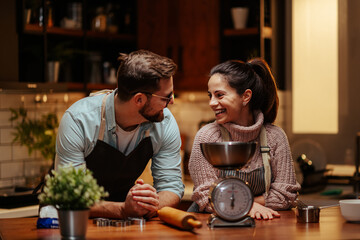 Smiling couple enjoying baking together in kitchen