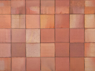 Coral brown terracotta ceramic tiles cladding texture for interior, exterior wall, dividing wall, facade, yard, floor. Natural handmade reddish pinkish outdoor square clay slabs background.	