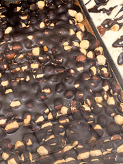 Decadent dark chocolate treat with crunchy nut topping provides indulgence