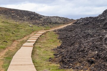 Wooden boardwalk winding through volcanic landscape in iceland