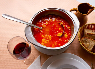 Spanish red soup cooked chickpeas, pepper and beef tripe, served at white bowl