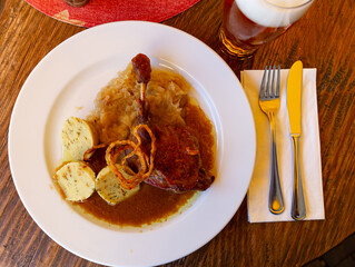 Confit duck leg with sauerkraut, potato dumplings and crispy onion