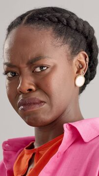 Black woman, face and disgust with negative emotion, nasty odor and gross smell. African person, unhappy and annoyed on gray background as cringe, stink and frustrated with reaction and expression