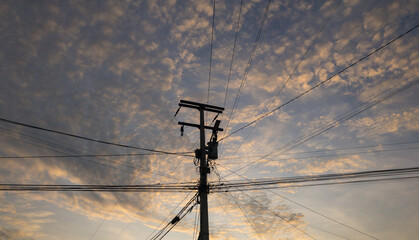 Power lines at sunrise with clouds.