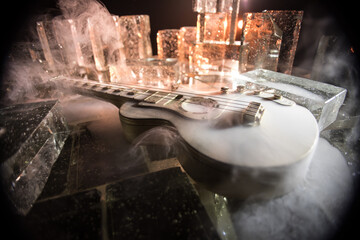 Music Concept: Guitar Miniature on a Dark Background with Vivid Light, Smoke, and Fire Effects. Golden electro guitar under a Dramatic Spotlight.