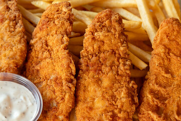 fried chicken nuggets or stripes with French fries. Detail.