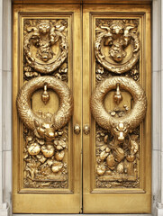 Ornate golden doors adorned with mythical dragon carvings and botanical relief sculptures.