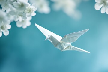 Origami bird flying, spring blossoms, blue background, peace concept