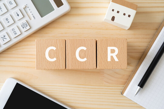 CCRと書かれたブロック、電卓、スマホ、建物の模型