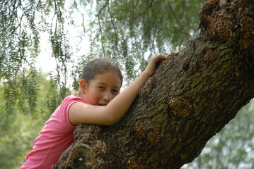 A small girl climbing a tree.