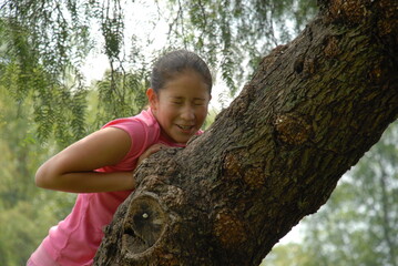 A small girl climbing a tree.