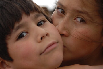 A sister giving a kiss to her brother. Children.