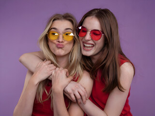 Playful Friends Embrace in Vibrant Red and Yellow Sunglasses