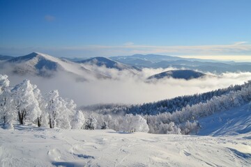 Snowy covered mountain top on winter with misty, cloud covered snow, high altitude peak.