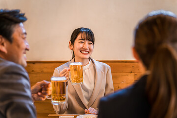 居酒屋・飲み屋で談笑する男女のサラリーマン
