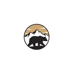 Obraz premium Mountain Bear Silhouette with Snowy Peaks and Golden Sky Background