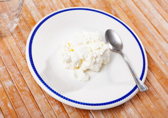 Portion of delicious fresh young curd cheese on a plate