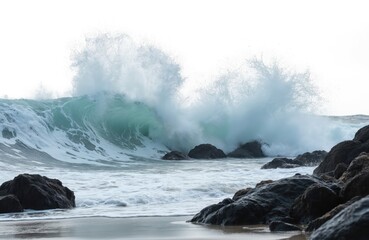 Powerful waves crash against rocky shore. Water splashes and sprays high into air. Ocean waves create dynamic motion. Cool water contrasts with dark rocks. Beach scene evokes natural beauty.