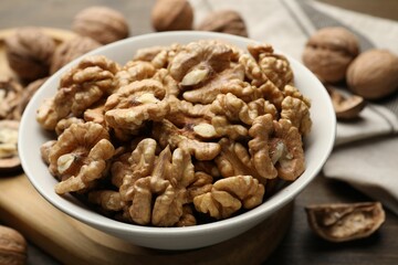 Peeled walnuts in bowl on table, closeup