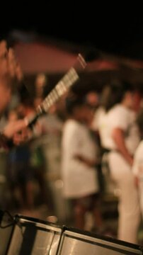detail of people in line playing bass drum instrument with drumsticks. street orchestra