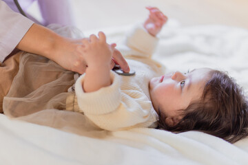 聴診器を当てられる赤ちゃん