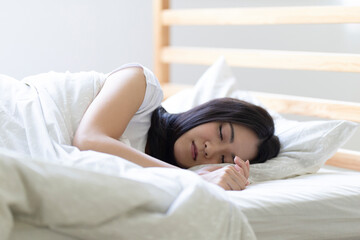 ベッドで寝る女性
