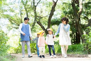 公園を散歩する保育士と園児