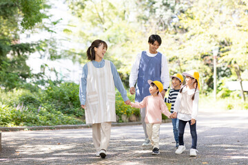 公園を散歩する保育士と園児