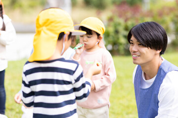 公園で遊ぶ保育士と園児