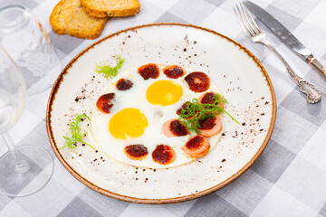 Appetizing scrambled eggs with sausage for breakfast closeup