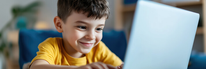 Engaged boy using laptop in modern classroom setting