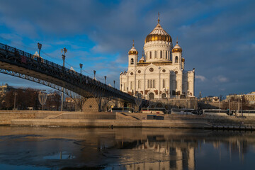 Fototapeta premium View of the Cathedral of Christ the Savior and the Patriarchal Bridge from the Beresnevskaya embankment of the Moskva River on a sunny winter day, Moscow, Russia